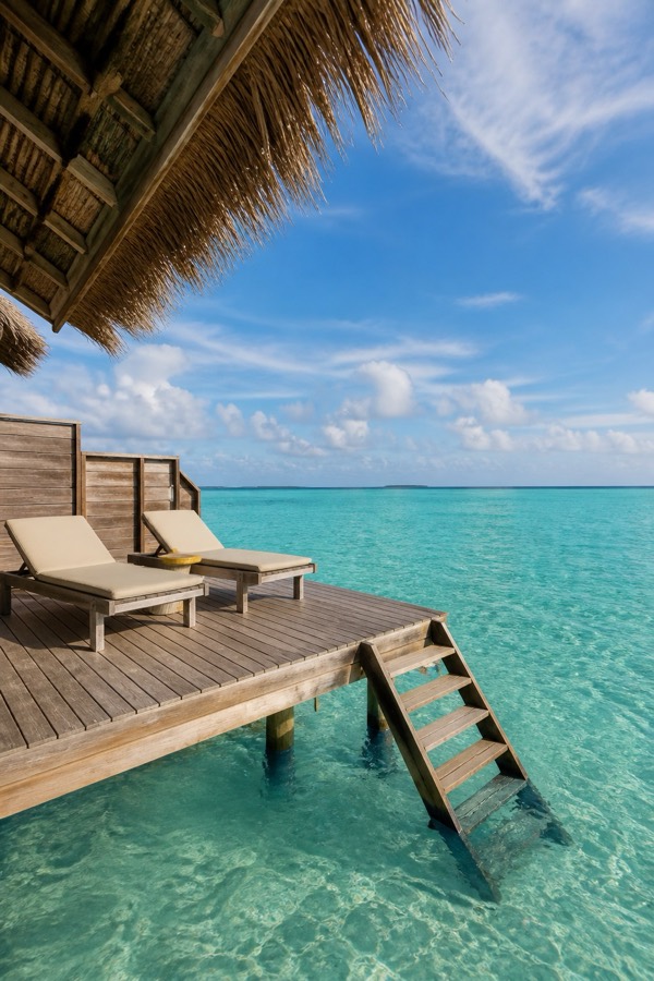 Overwater villa deck above a turquoise lagoon